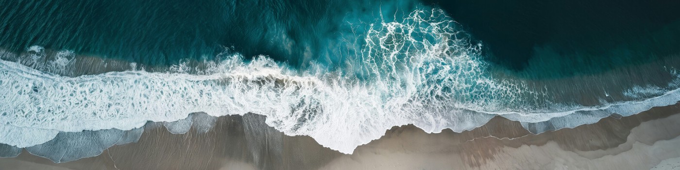 Aerial view of white surf meeting pale sand